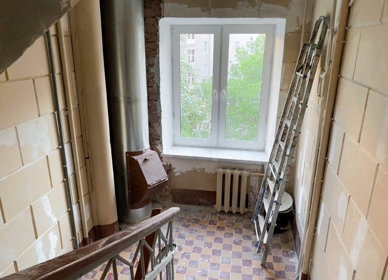 Travaux de réparation, rénovation de l'entrée d'un immeuble d'habitation. Cage d'escalier, fenêtre, vide-ordures