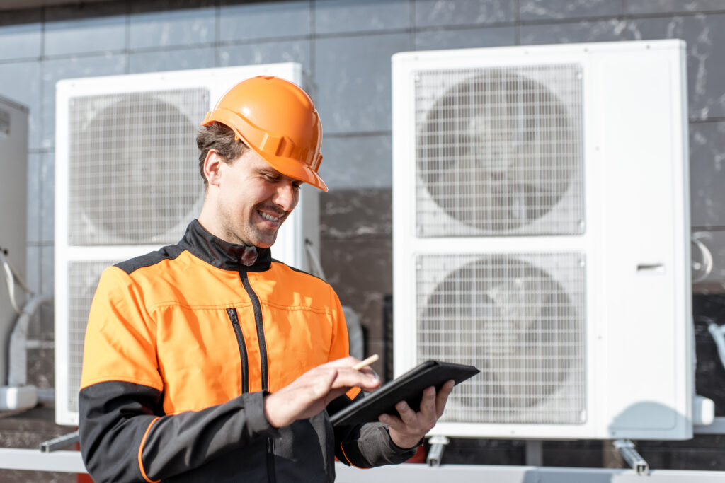 Workman entretien de la climatisation ou de la pompe à chaleur avec tablette numérique